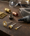 Top Shelf Brass Wire Brush Kit For Knocking Out Rust And Buffing To Perfection With Three Mm Shank That Clicks Straight Into Your Drill Or Rotary Tool 60 Piece Crate with various brush sizes on a wooden workbench.