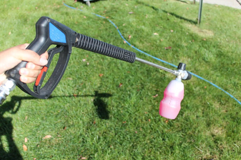 SG28 Spray Gun With Easy Hold Tech For Pressure Washers in action, held outdoors, showing trigger and nozzle attachment.