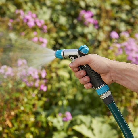 Hand using Front Control Garden Hose Nozzle With Adjustable Spray Pattern, Ergonomic Non Slip Grip in garden
