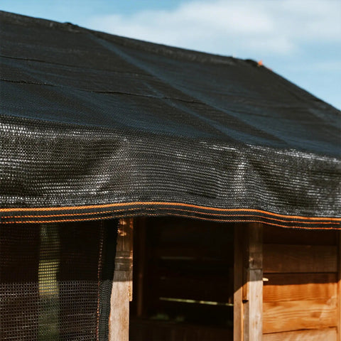 Shade Cloth 70 Percent, 20x20 Ft Heavy Duty Durable Mesh Tarp With Grommets covering a wooden structure, weatherproof for garden use.