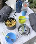 Two Person Camping Cook Set With Nesting Design Deep Dish Bowls And Double Wall Insulated Mugs Lightweight Two Liter Hard Anodized Pot Nonstick PFOA Free Safe For Hot Or Cold Meals Ideal For Backpacking Or Family Camps on a table with pasta and camping accessories