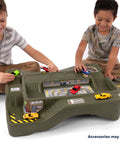 Two children playing with the Monster City Extreme Wheels Race Track Table For Kids, featuring cityscape and off-road tracks.