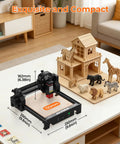 Starter Friendly 2500mW Laser Engraver With Portable Cutter 130x130mm Working Area on table with wood models nearby