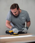 Man using Top Tier 6 Inch Random Orbital Sander Featuring A Smooth Brushless Motor And Effective Dust Extraction on wood.
