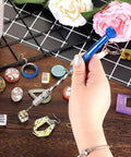 Hand holding a blue pin vise from the Premium 46 Piece Pin Vise Hand Drill Set With 45 Mini Twist Drill Bits Ranging From 0.3 To 3 Mm Hella Reliable For Diy Wood Clay Resin Casting Jewelry Pendant Crafting Supplies.