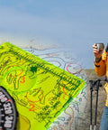 Hiker using Orienteering Compass For Hiking And Camping, Pro-Grade Scout Tool For Map Reading And Navigation with landscape map.