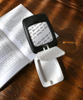 Pocket Magnifier With Light And Stand 3X Magnification Handy Portable 2-In-1 LED Desk Magnifier in use for reading text on a book