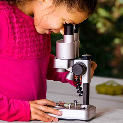 Child using Dual LED Kids Microscope Set With 50 Plus Piece Science Kit for biology experiments, focused on slide viewing.