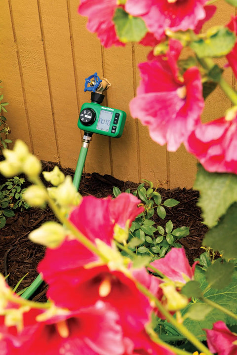 Electronic Digital Hose End Timer For Garden Irrigation, Battery Operated, attached to hose with flowers in foreground