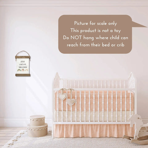 Nursery setup with Jesus Loves Me This I Know hanging canvas with boho rainbow, crib, and decorative accents.