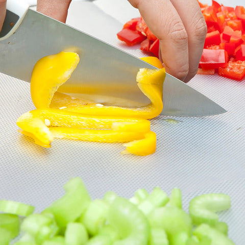 Slicing yellow bell pepper on EZ Board Disposable Plastic Cutting Board For Quick Cleanup And Easy Food Prep On The Go, 20 Square Feet.