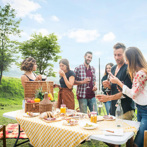 Group enjoying a picnic on a Six Foot Folding Table For Indoor Outdoor Use, Portable Long Rectangular Table With Carrying Handle.