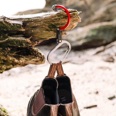 HeroClip Carabiner Gear Clip And Hook Medium For Camping Hiking And Garage Organization Versatile 3in1 Clip That Hangs Anything Secure Grip Up To 60 Lbs Rubber Tip For Stable Hold Blue Steel 2 Pack used to hang boots on a tree branch.