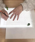 Person using Portable LED Light Pad For Crafting And Quilting 10 By 13 Inch, Ultra Bright Four Level Illumination For Clear Tracing And Cutting.