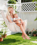 Woman with child in beige Heavy Duty Hammock Chair With Steel Spreader Bar And Adjustable Straps for outdoor use.