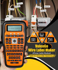 Handheld Labeling Machine With Tape For Industrial Office Use Pro Grade Waterproof Laminated 12Mm Cable Labeler For Wires And Cables E1000 Labeler With Three Cable Modes And One Touch Keys Heat Shrink Ready held in hand, displaying screen and buttons in front of labeled wires and cables.
