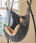 Woman relaxing in dark gray Hammock Chair With Stand For Indoor And Outdoor Use, Chill Egg Swing Chair with adjustable pillow.
