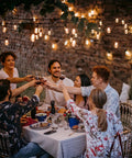 Outdoor dinner party under two 50 foot dimmable Edison style shatterproof string lights with 32 LED bulbs 100 feet total