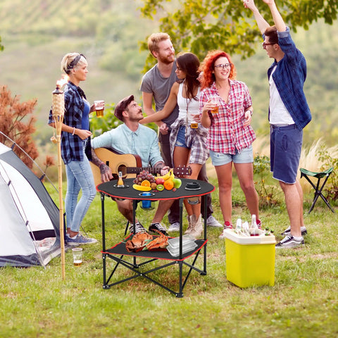 Outdoor scene with friends using a Portable Folding Picnic Table For Outdoors With 4 Cup Holders, on grass during a picnic.