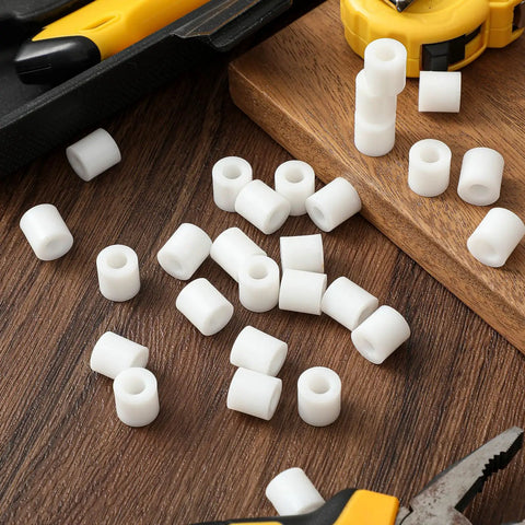 200 Pcs Heavy Duty Nylon Spacers White Half Inch Thick round insulated electrical outlet screw washers scattered on wood surface.