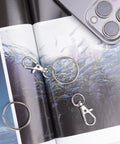 Hella Durable Premium Silver Swivel Snap Hooks 50 Pack Lobster Claw Trigger Clasps on photo album with fish design.