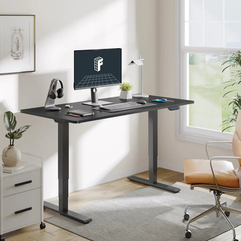 Height adjustable standing desk with a spacious 60 by 24 top, matte black frame, and dual motor lift in a bright workspace.