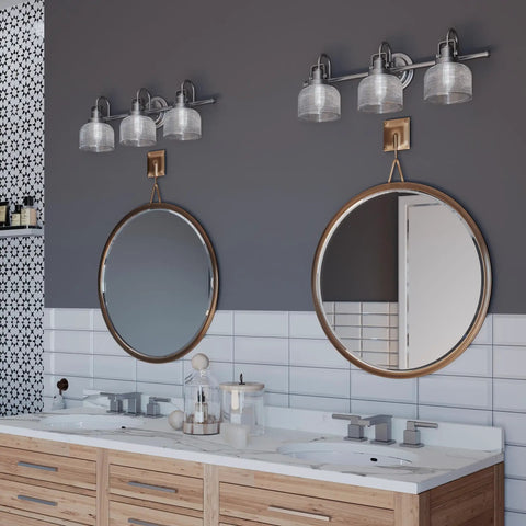 Bathroom setting with Archie Collection 3-Light Bath Vanity Light with Double Prismatic Glass in Antique Nickel above double mirrors.