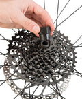 Hand using FR-5.2 Bicycle Cassette Lockring Tool With 12-Spline Design on Shimano disc brake lock rings in bike wheel maintenance.
