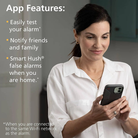 Woman using phone app for 2 In 1 Smoke Detector And Indoor Air Quality Monitor With WiFi And Alexa Compatibility Hardwired With Battery Backup Voice And App Alerts For Smoke Hazards And TVOC Levels At Home.