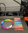 MultiColor Filament Feeder Upgrade Kit Compatible With Mk3s Plus Mk4 Mk4s Core Handles 12 Spools Rolls on a 3D printer bed.