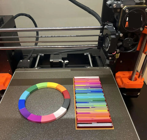 MultiColor Filament Feeder Upgrade Kit Compatible With Mk3s Plus Mk4 Mk4s Core Handles 12 Spools Rolls on a 3D printer bed.