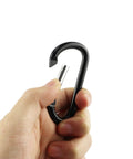 Hand holding black Aluminum Carabiner Clip Snap Hook Keychain Set Black With Multiple Sizes 1.5 1.9 2.2 2.4 2.8 Inch Carabiners For Keys Backpacks Lanyards And Light Gear Durable Go To Everyday Carry.