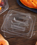 10 Pack 1/6 Size Crystal Clear Polycarbonate Food Pan Lids With Secure Handles Universal Restaurant Kitchen Covers stacked on a wooden table.