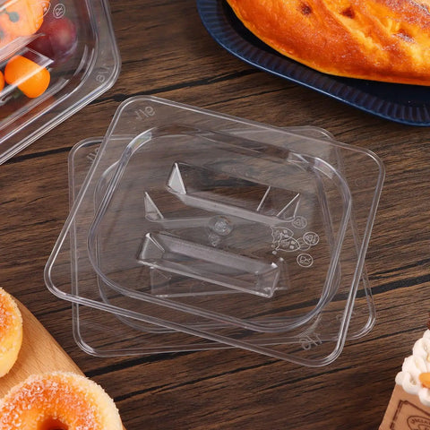 10 Pack 1/6 Size Crystal Clear Polycarbonate Food Pan Lids With Secure Handles Universal Restaurant Kitchen Covers stacked on a wooden table.