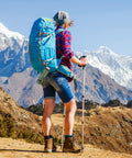 Hiker carrying blue backpack with Three Inch Aluminum Carabiner D Ring Clip Set of 10 With 30mm Steel Rings in mountain landscape.