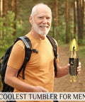 Man holding 17oz Gold Stainless Steel Tumbler With American Flag Tool Design And I Fix Stuff And I Know Things Phrase in forest