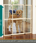 Expandable Wire Mesh Dog Gate For Doors And Hallways Pressure Mounted No Tools Needed 29.5 To 40 Inch Wide And 37 Inch Tall Durable American Hardwood Pet Gate With Vinyl Coated Mesh For Safe Home Boundaries shown with dog behind gate in doorway.