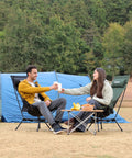 Couple enjoying drinks on Portable Lightweight Folding Camping Chair With High Back And Pillow, Deep Recline in campsite.