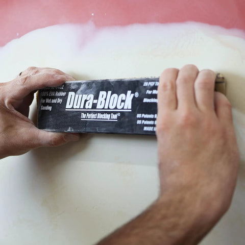 Hands using Six Piece Flexible EVA Foam Auto Body Sanding Block Kit for Wet or Dry Sanding on vehicle surface.