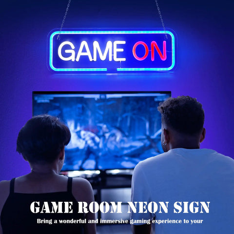 Lit Gaming Neon Sign Light For Bedroom Decor above gamers with "Game On" text illuminated in blue and red LED, creating atmosphere.