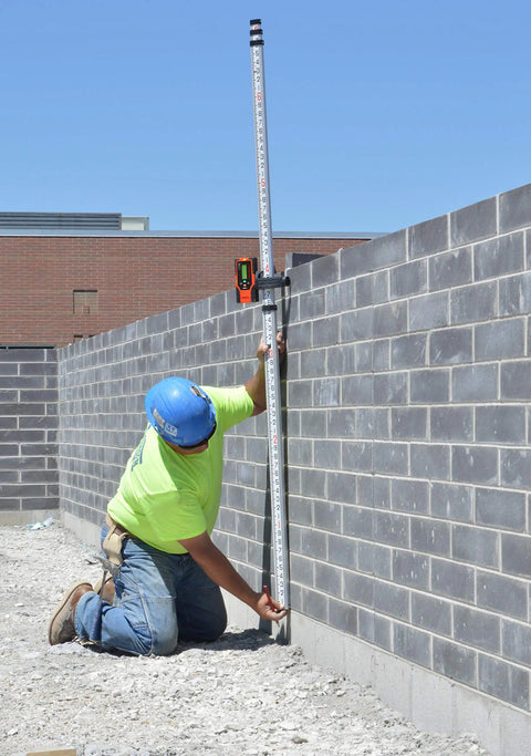 Construction worker using Two-Sided Laser Detector With Clamp For Red Beam Rotating Lasers Outdoors No-Nonsense Pro-Grade Targeting