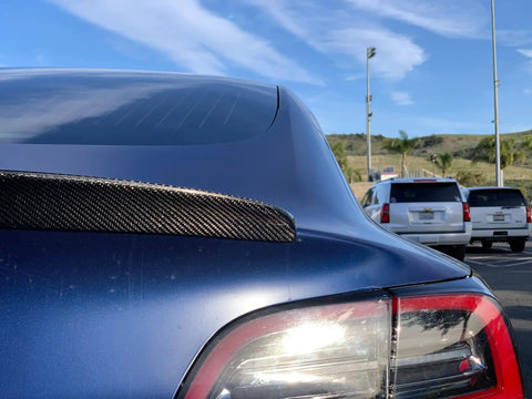 Real Molded Carbon Fiber Matte Dry Look Spoiler For Tesla Model 3 on a blue car, showcasing aerodynamics and sleek design.