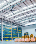 Massive 24ft HVLS Industrial Ceiling Fan For Large Warehouses And Factories pumping out serious airflow above packaged goods.