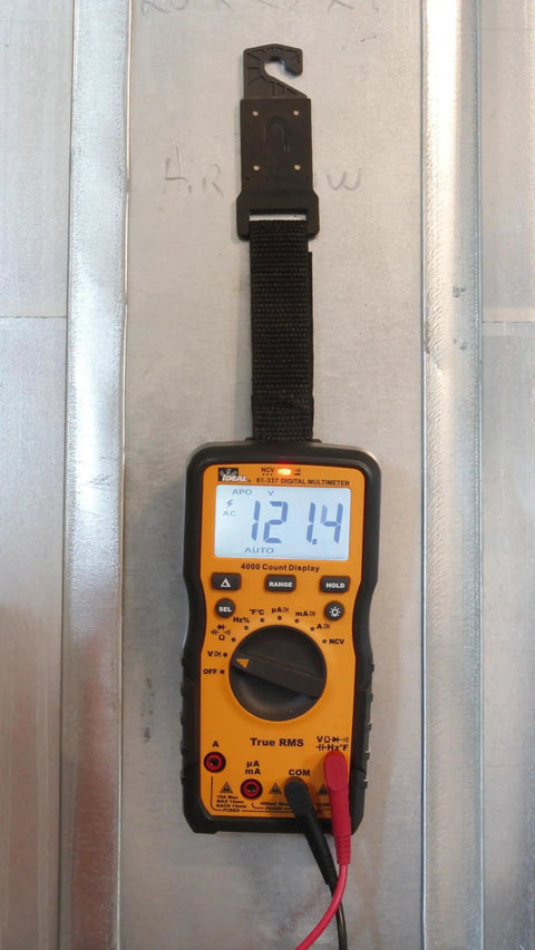 Auto Range Digital Multimeter 600V CAT III NCVT Temp with Backlit Display hanging on metal wall using strap clip