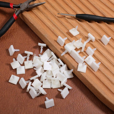 100 Pack Nylon PCB Adhesive Standoffs For Circuit Boards 0.25 Inch Insulated Spacers scattered on a wooden surface with tools.