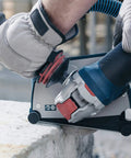 Badass Torque 120 Volt 10 Amp X Lock Mount 4 1/2 Inch Corded Angle Grinder cutting concrete with ergonomic grip.