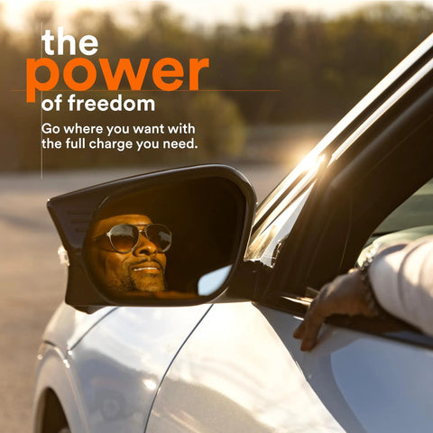 Reflection of a smiling person in sunglasses in a car mirror, with text about the power and freedom of electric vehicle charging.