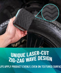 Hand using Wonder Wave Durafoam Tire Shine Applicator Pad on truck tire sidewall with zig-zag wave design visible.