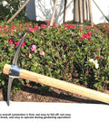 Stainless Steel Hand Tiller And Cultivator Garden Tool With Hardwood Handle for Digging and Weeding in vegetable gardens, leaning in a garden.