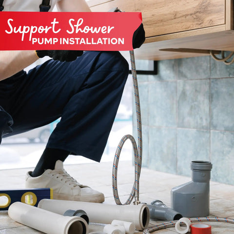 Plumber installing shower pump with tools and pipes on tiled floor.